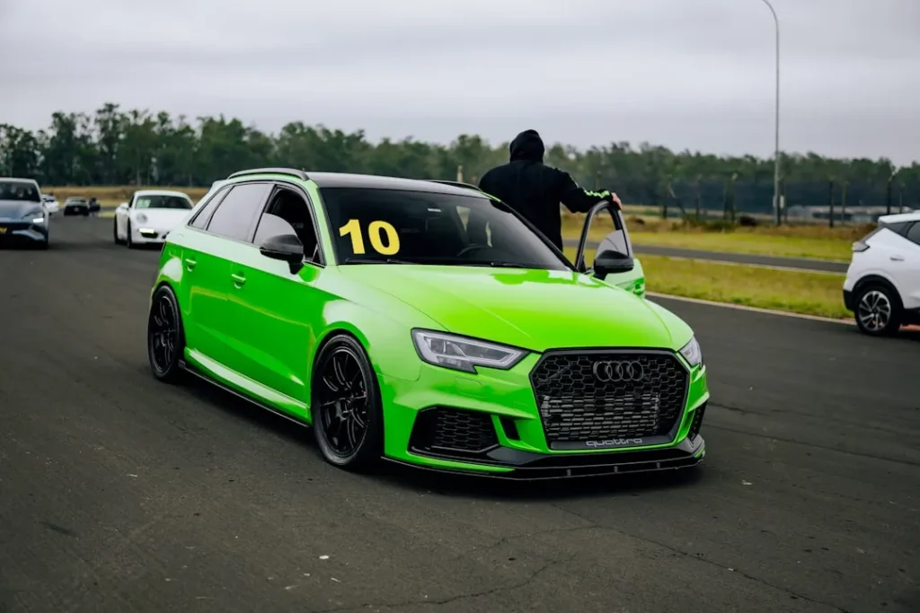 A green car driving down a race track