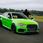A green car driving down a race track