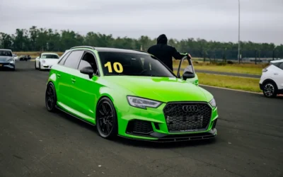A green car driving down a race track