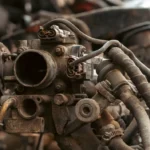 Close-up of a rusty old car engine carburetor.