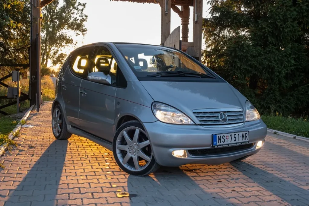 A small silver car parked in front of a gazebo