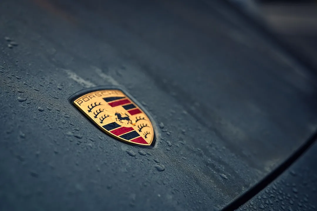 Porsche emblem on a wet car surface