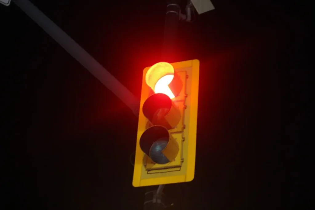 a traffic light with a red light in the dark